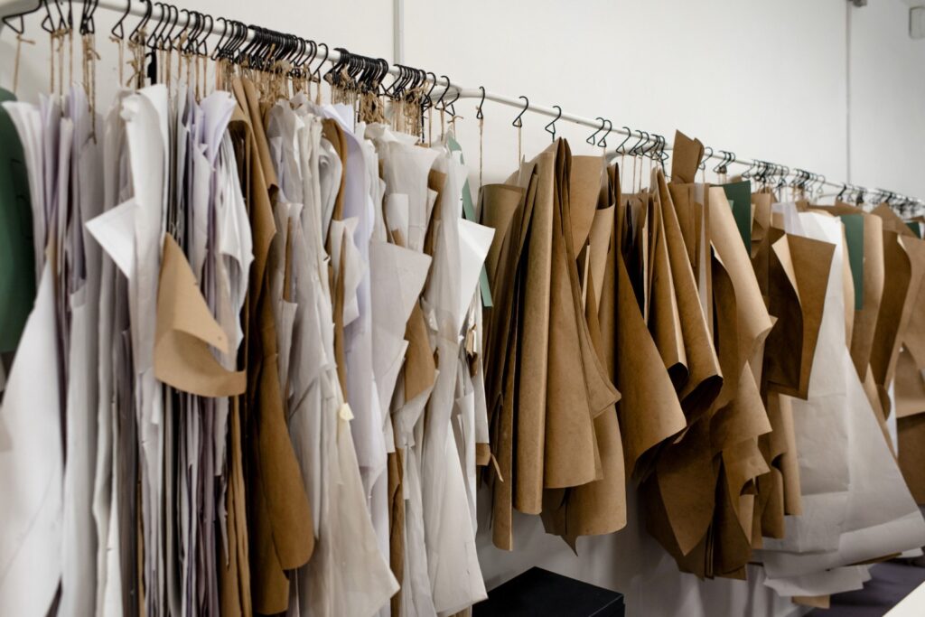 Paper garment patterns organised on a rail for apparel pattern development