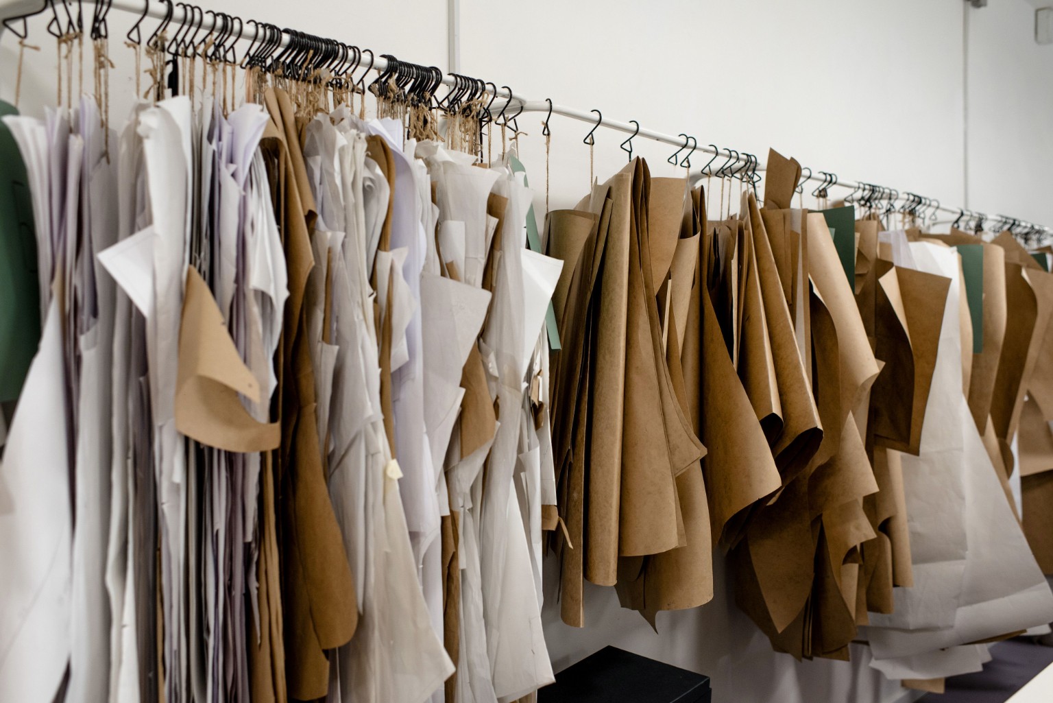 Paper garment patterns hanging in a design workspace
