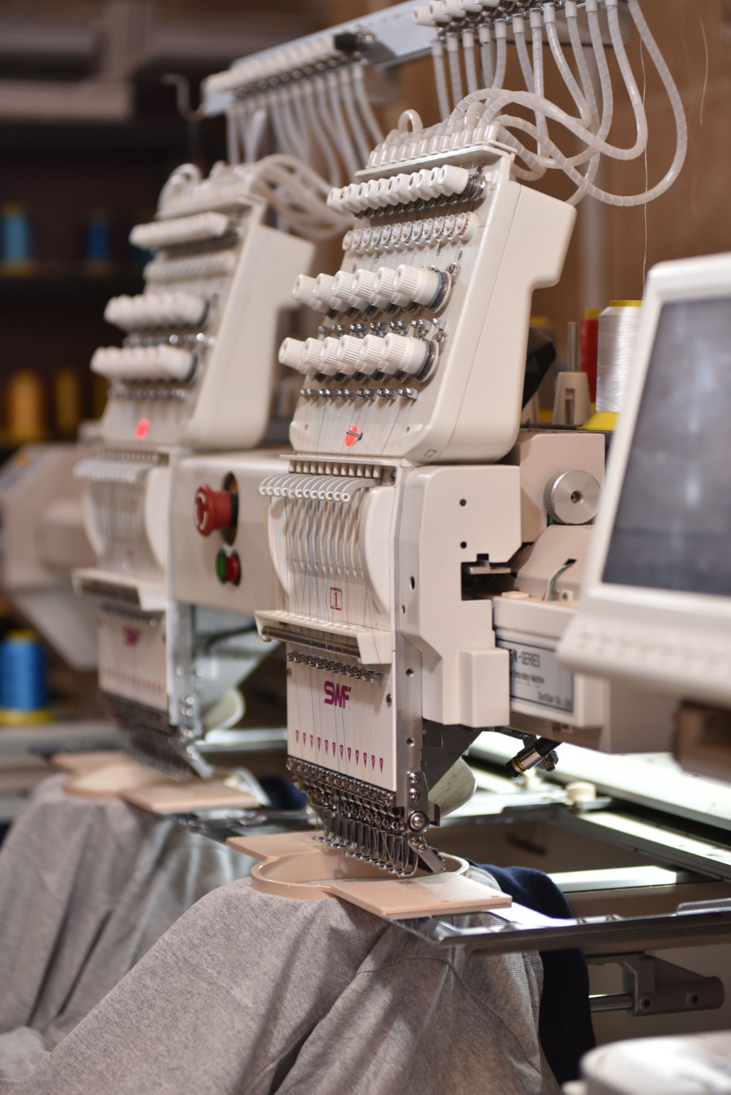 Multi-head embroidery machines working on grey garments