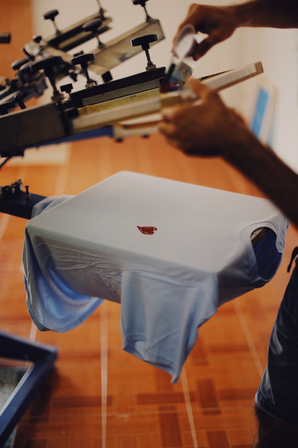 A T-shirt positioned on a manual screen-printing press