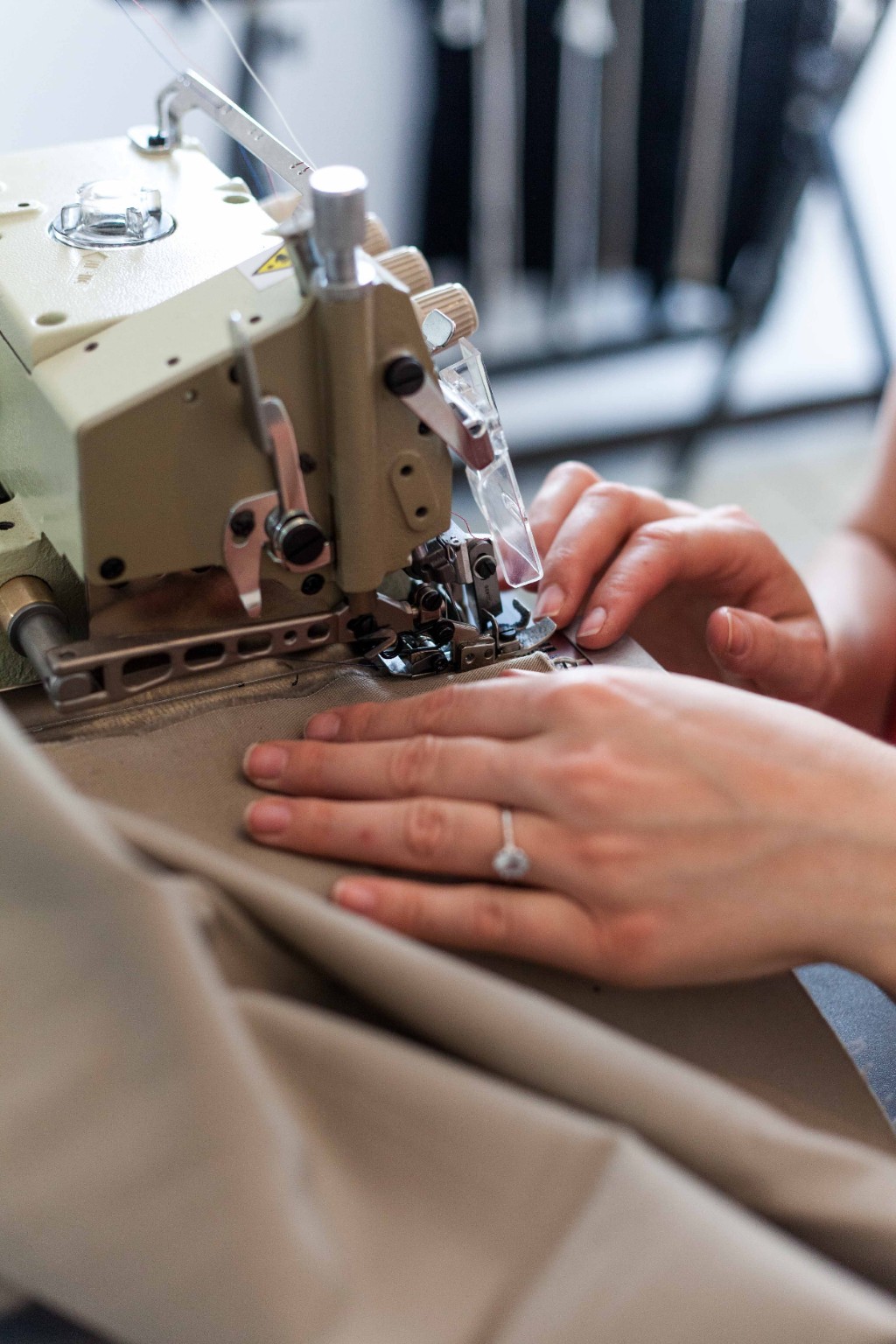 Hands finishing a fabric edge with an overlock sewing machine